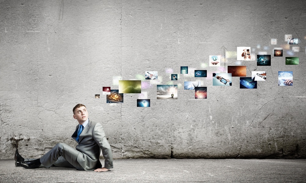 Image of young man sitting on floor looking on media icons.jpeg